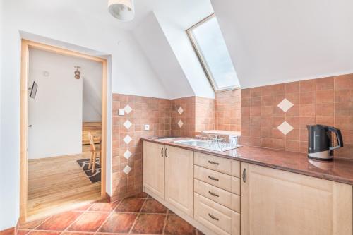 a kitchen with a sink and a skylight at Góralski Dworek in Czarna Góra