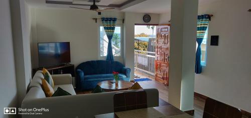 ein Wohnzimmer mit einem Sofa und einem TV in der Unterkunft Island Cliff in Port Blair