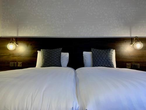 two beds sitting next to each other in a bedroom at Trafford Hall Hotel Manchester, Trademark Collection by Wyndham in Manchester