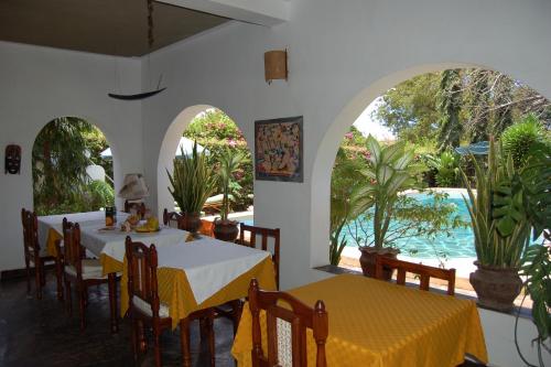a dining room with two tables and a view of the water at JoysVilla Family Holiday Home in Malindi