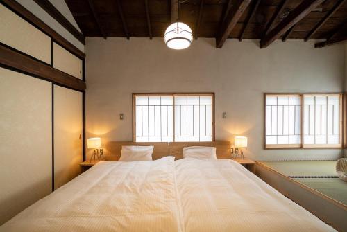 a large bed in a room with two windows at Ebisuya / Vacation STAY 5850 in Kofu
