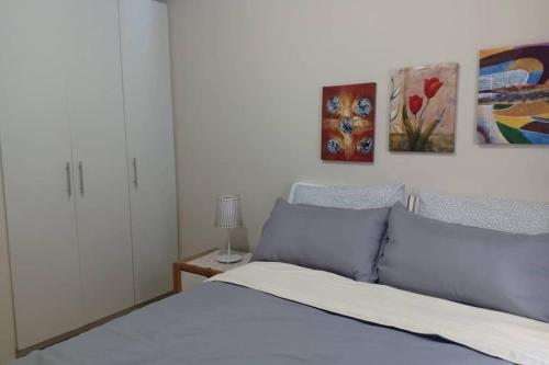 1 dormitorio con 1 cama y pinturas en la pared en 2BR Apartment - Pasig Stay, en Manila