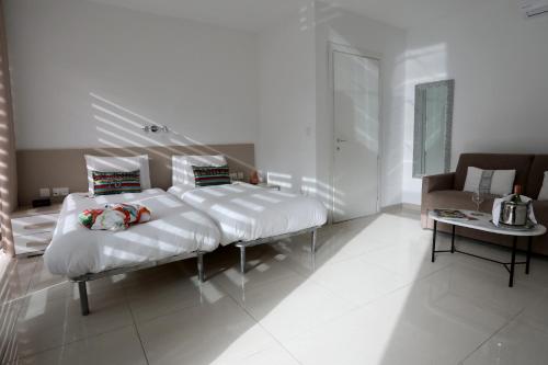 a white room with a bed and a couch at Escape to St Julians in St Julian's