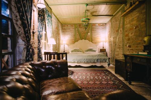 a bedroom with a bed and a leather couch at Vila Terrasse in Košice