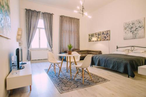 een slaapkamer met een bed en een tafel en stoelen bij Entrez Apartment 3 - Historical Centre in Košice