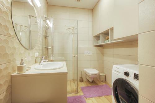 uma casa de banho com um lavatório e uma máquina de lavar roupa em Mint Studio em Druskininkai