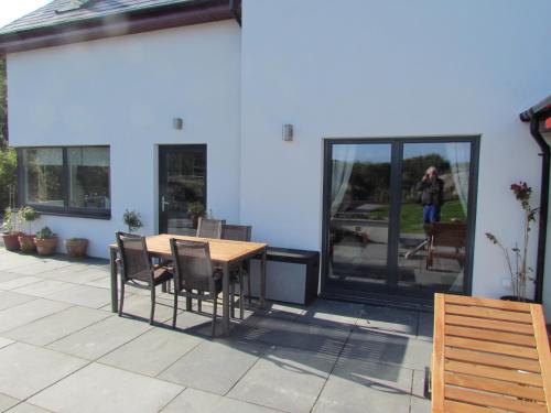 a patio with a table and chairs and a building at Romantic Hideaway in Goleen