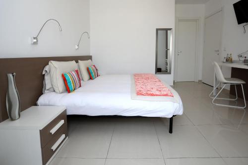 a bedroom with a large bed and a desk at Escape to St Julians in St Julian's
