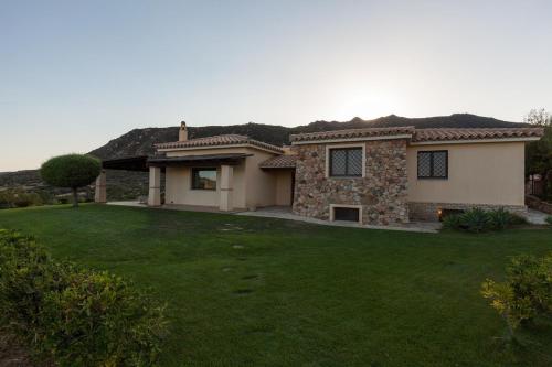 a house with a green lawn in front of it at Villa Anna Maria in Villasimius