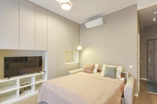 a bedroom with a bed and a flat screen tv at Mint Studio in Druskininkai