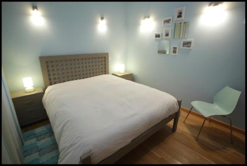 a bedroom with a bed and a chair and lights at Casa da Irene in Nazaré