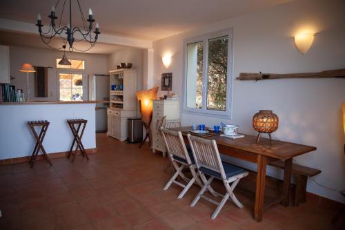 une cuisine et une salle à manger avec une table et des chaises en bois dans l'établissement Casa Vadde Lungha superbe vue mer 8 personnes, à Coti-Chiavari