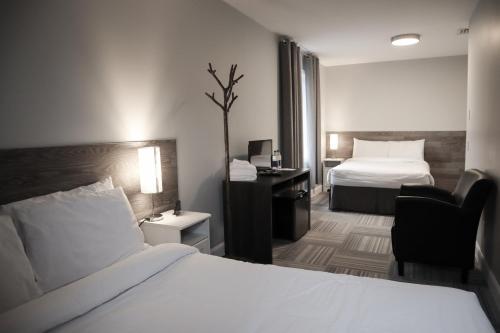 a hotel room with a bed and a desk at Auberge Valcartier in Saint-Gabriel-De-Valcartier