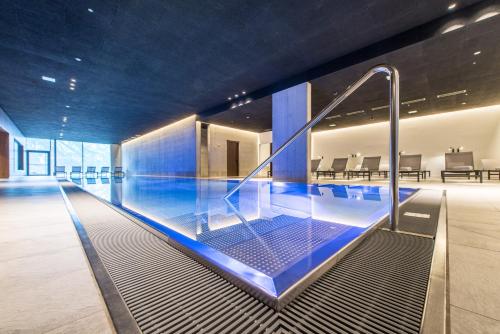 a swimming pool in a building with blue walls at Mountain Residence Montana in Santa Maddalena
