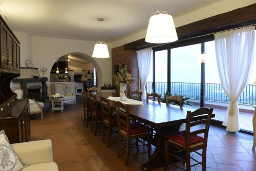 a dining room and living room with a table and chairs at Villa Pace in Piedimonte Etneo