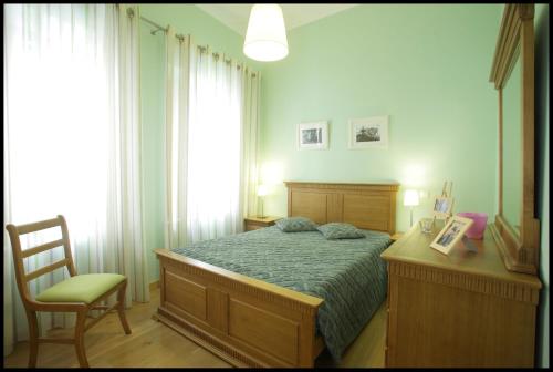 a bedroom with a bed and a desk and a chair at Casa da Irene in Nazaré
