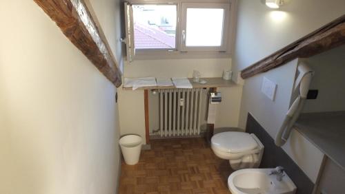 a small bathroom with a toilet and a window at Artua'&Solferino in Turin