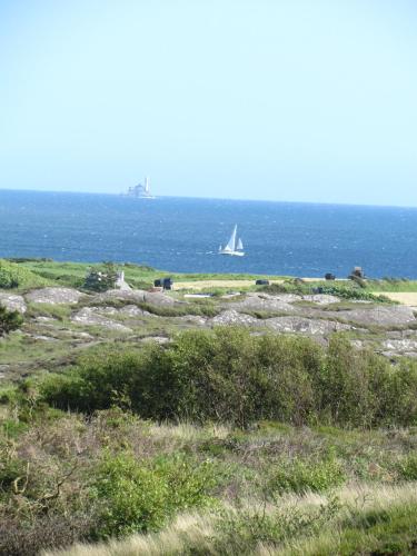 a sail boat in the ocean with a boat in the water at Romantic Hideaway in Goleen