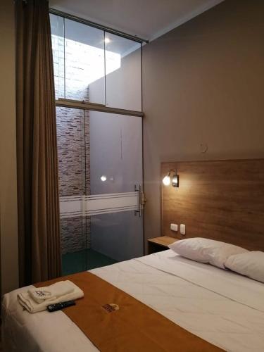 a bedroom with a bed and a large window at HOTEL PIEDRA SANTA - Moquegua in Moquegua