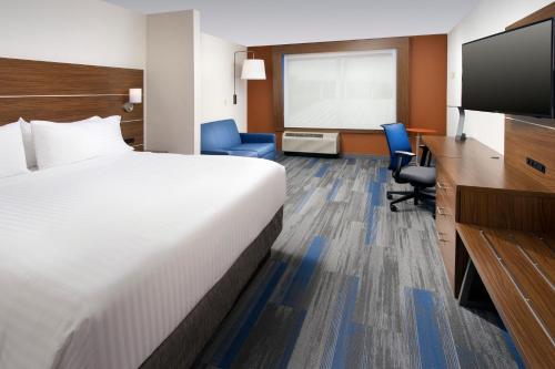 a hotel room with a bed and a flat screen tv at Holiday Inn Express & Suites by IHG Altoona by IHG in Altoona