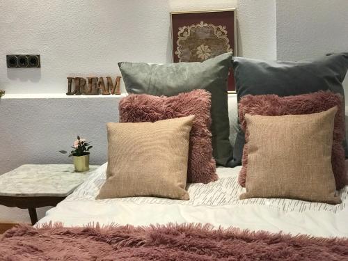 a bed with several pillows on top of it at Apartamento with Jacuzzi & sea view in Alicante