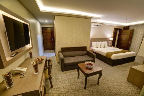 a hotel room with a bed and a couch at Nairoukh Hotel Aqaba in Aqaba