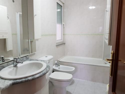 a bathroom with a sink and a toilet and a bath tub at Hostal Ponte Dos Santos in Ribadeo