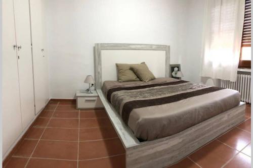 1 dormitorio con 1 cama grande y suelo de madera en ALOJAMIENTO CON JARDIN 20KM BARCELONA en Vilassar de Dalt