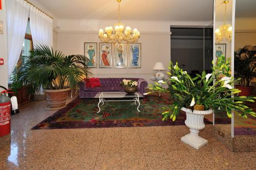 a living room with a couch and potted plants at Grand Hotel Tettuccio in Montecatini Terme