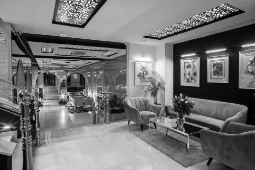 a living room with couches chairs and a table at Hôtel Tanjah Flandria in Tangier