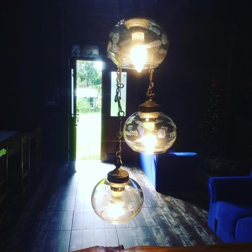 a light hanging from a ceiling in a dark room at CHALÉ ESTÂNCIA OURO VERDE in Lages