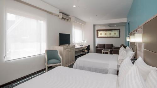 um quarto de hotel com duas camas e uma televisão em Holiday Inn & Suites Mexico Zona Reforma, an IHG Hotel em Cidade do México