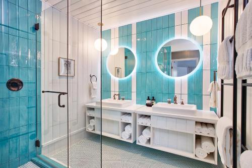 a bathroom with two sinks and two mirrors at Dive Palm Springs in Palm Springs
