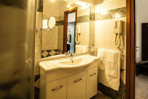 W łazience znajduje się umywalka i lustro. w obiekcie Hotel Davide w mieście Rivoli