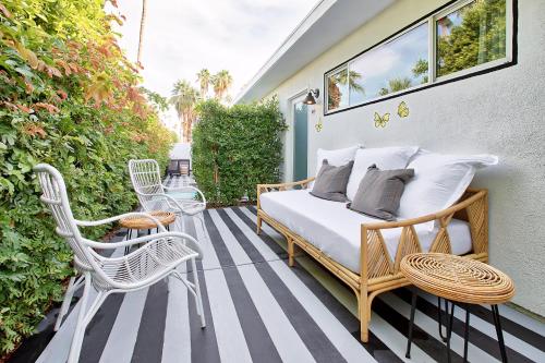 a bedroom with a bed and chairs on a patio at Dive Palm Springs in Palm Springs