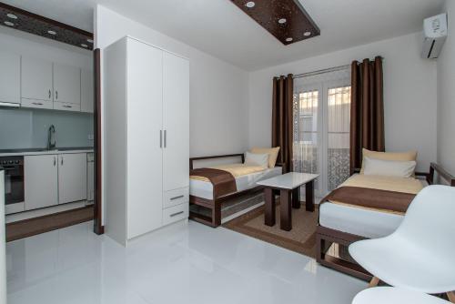 a small room with two beds and a kitchen at Hazam Apartmani in Sanski most