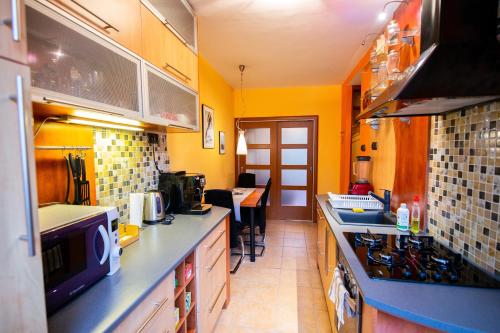 cocina con paredes amarillas y encimeras azules en Apartman Orlie Pierko - Tatranska Lomnica, en Tatranská Lomnica