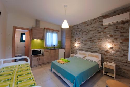 um quarto com uma cama e uma parede de tijolos em Holiday Rooms em Otziás