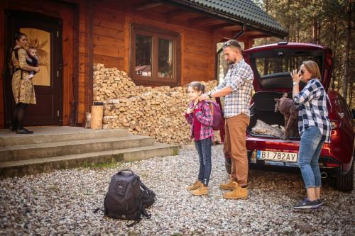a man and a woman and a child standing next to a car at Łosia Chata in Grzybowce
