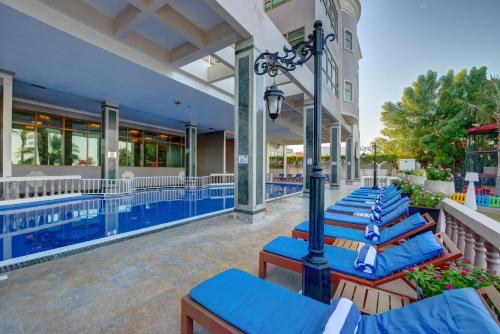 a row of blue lounge chairs next to a pool at Sahara Beach Resort & Spa in Sharjah