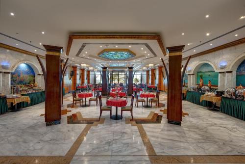 a dining room with red tables and chairs at Sahara Beach Resort & Spa in Sharjah