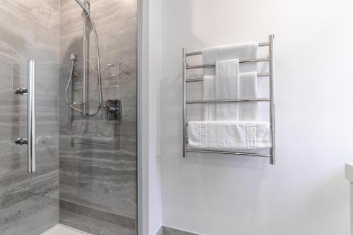 a bathroom with a shower with towels on a towel rack at MyHolidays - The Four Seasons Queenstown in Queenstown
