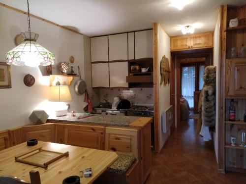 a kitchen with wooden cabinets and a table in it at Pescocostanzo Centro in Pescocostanzo