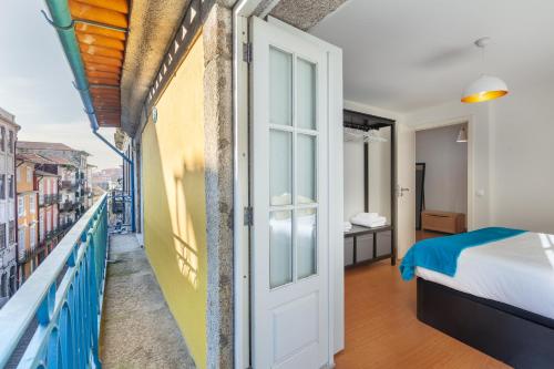 1 dormitorio con 1 cama y balcón en Casa S. Miguel 6, en Oporto