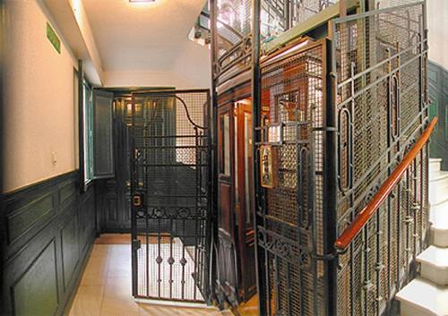 korytarz z drzwiami z kutego żelaza w budynku w obiekcie Hostal Santa Isabel w Madrycie