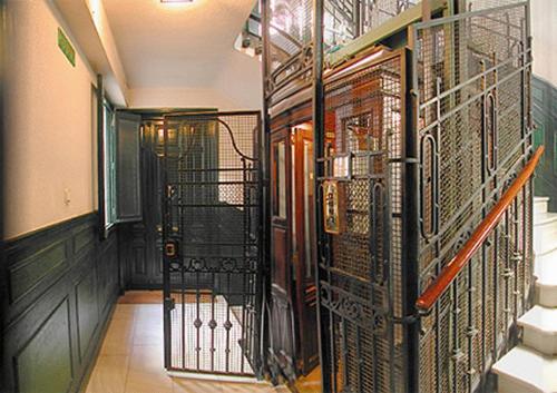 un couloir avec des portes en fer forgé dans un bâtiment dans l'établissement Hostal Santa Isabel, à Madrid