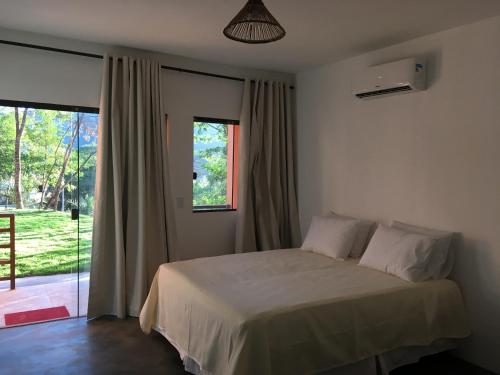 a bedroom with a bed and a window at Pousada Mandala do Vale in Vale do Capao