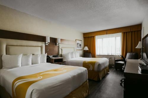 ガティノーにあるQuality Inn & Suitesのベッド2台と机があるホテルの部屋