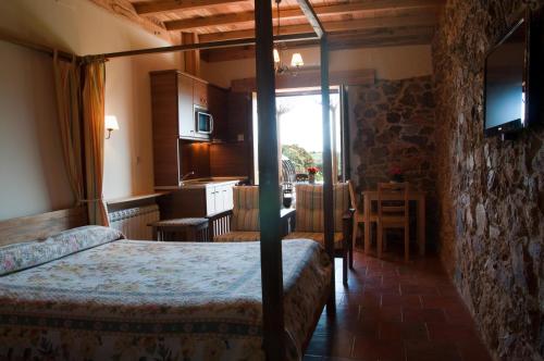 1 dormitorio con 2 camas, cocina y mesa en Apartamentos El Jardín del Poeta, en Guijo de Granadilla