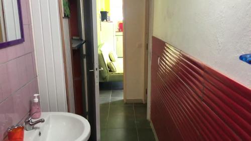 a bathroom with a sink and a green chair at Domaine De Titine in Bonneville
